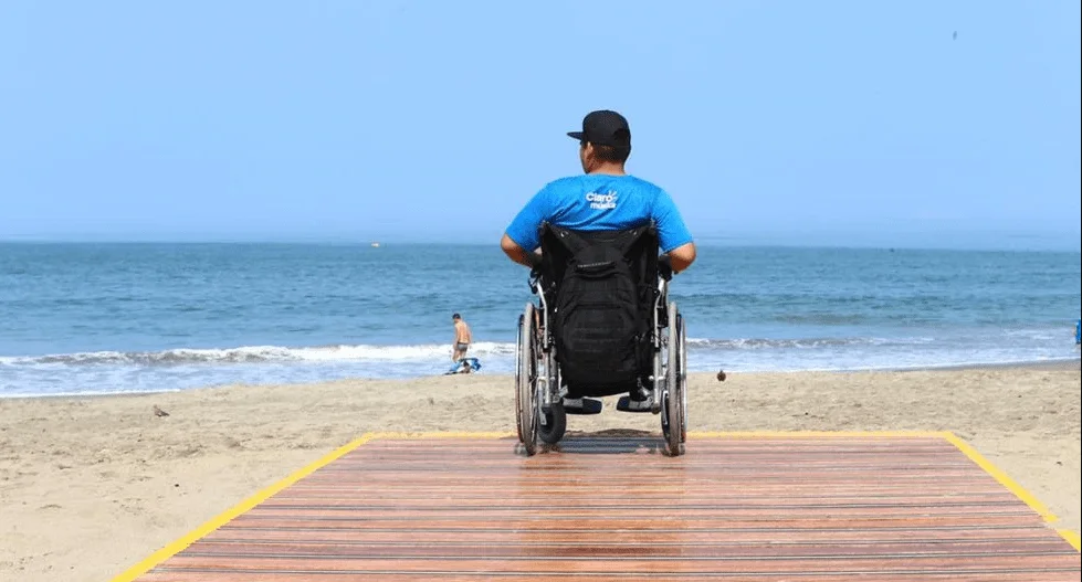A wheelchair user in the accessible area of the beach, about 20 metres from the shoreline.